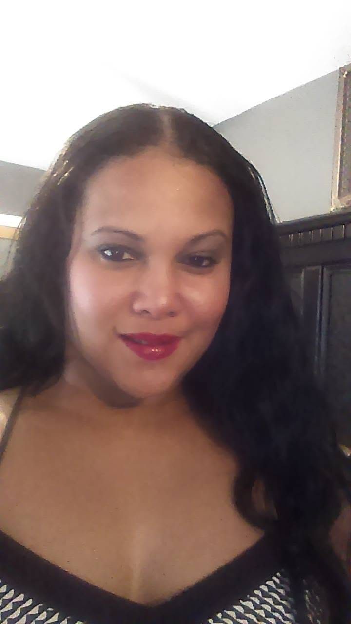Teola Blake smiling, wearing a black top, indoors at home.